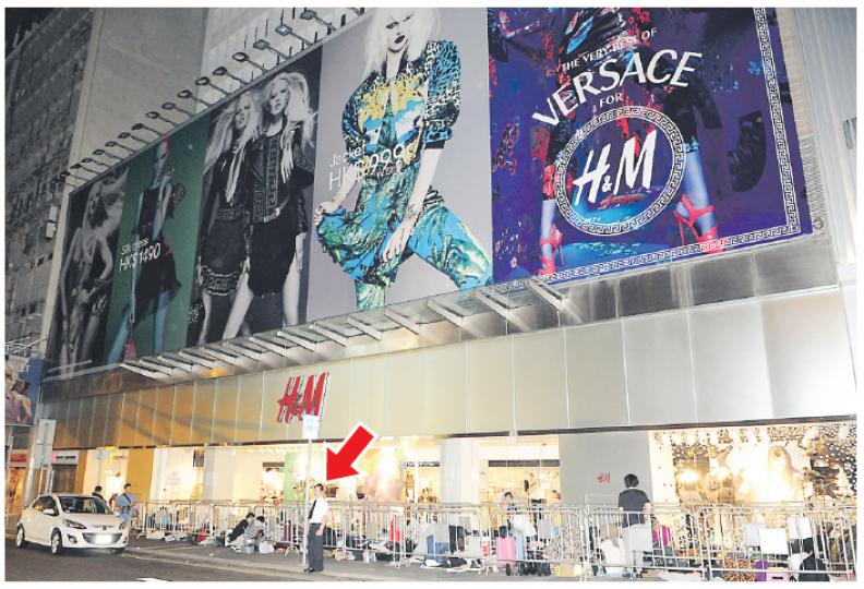 人群在中環H&M旗艦店門外排隊期間,有保安員(箭嘴示)在旁維持秩序,防止有人混水摸魚打尖。(蔡方山攝) 人群在中環H&M旗艦店門外排隊期間,有保安員(箭嘴示)在旁維持秩序,防止有人混水摸魚打尖。(蔡方山攝)