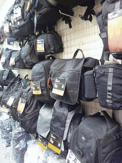 海關掃蕩前,涉案店舖掛出多個未知真假的「Lowepro」相機袋,售價較附近店舖便宜。(明報記者攝) 海關掃蕩前,涉案店舖掛出多個未知真假的「Lowepro」相機袋,售價較附近店舖便宜。(明報記者攝)