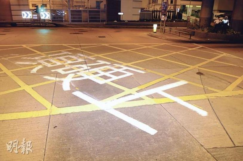 警方接獲獅隧職員報告指有人在窩打老道馬路上塗鴉,到場後見「項硬上」三個大字印在路面黃格位置(圖)。昨凌晨約4時,警方在距離塗鴉約10米的天橋底,發現裝有白色油漆的水桶,旁邊有一罐同色油漆及一把油掃,相信是塗鴉者留下的工具(圖3)。(蔡方山攝) 警方接獲獅隧職員報告指有人在窩打老道馬路上塗鴉,到場後見「項硬上」三個大字印在路面黃格位置(圖)。昨凌晨約4時,警方在距離塗鴉約10米的天橋底,發現裝有白色油漆的水桶,旁邊有一罐同色油漆及一把油掃,相信是塗鴉者留下的工具(圖3)。(蔡方山攝)