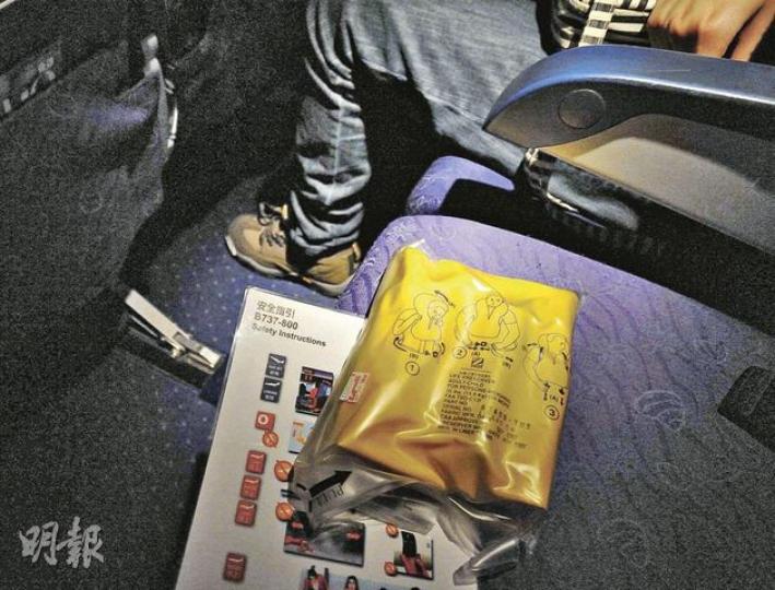 本報記者昨日乘香港快運航班從哈爾濱返港,座位下的救生衣以橡筋索帶綁住,輕易就能取出,體積只有約一本筆記大小,能放進隨身手提袋內,而記者拍照後則放回原位。(明報記者攝) 本報記者昨日乘香港快運航班從哈爾濱返港,座位下的救生衣以橡筋索帶綁住,輕易就能取出,體積只有約一本筆記大小,能放進隨身手提袋內,而記者拍照後則放回原位。(明報記者攝)