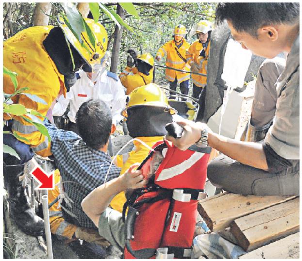 失足墮坡男子遭鐵通貫穿左腰(箭嘴示),反應鎮定,消防員需用電鋸拯救,工友則扶着生理鹽水樽協助傷者「吊鹽水」。(蔡方山攝) 失足墮坡男子遭鐵通貫穿左腰(箭嘴示),反應鎮定,消防員需用電鋸拯救,工友則扶着生理鹽水樽協助傷者「吊鹽水」。(蔡方山攝)