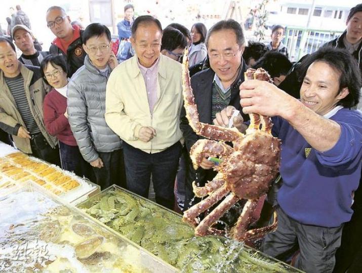 特首參選人唐英年（右二）昨日到西貢派發競選單張，有檔販向他展示生猛海鮮。右三是西貢區議會主席、民建聯吳仕福。（李澤彤攝）
