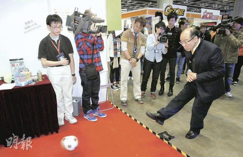 特首參選人馮檢基（右）建議成立500億基金發展六大優勢產業。圖為他昨日在「亞洲遊戲展」，試玩「足球九宮格」。（林振東攝）