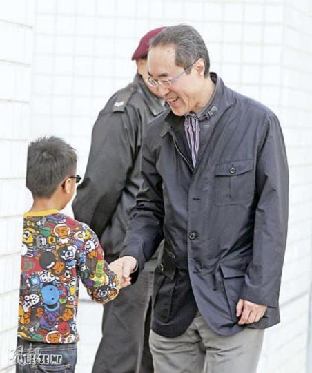 特首參選人唐英年（右）昨日回應中聯辦宣傳文體部部長郝鐵川批評港大的身分認同民調，指會尊重學術和言論自由。圖為他到杏花邨探訪中產後，和小朋友握手。（李澤彤攝）