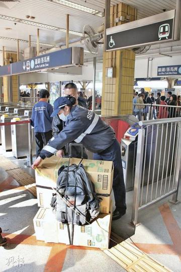 港鐵附例特檢隊人員於上水火車站的熱門水貨集散地,抽查並量度疑違規的過大貨品。(林錫禮攝) 港鐵附例特檢隊人員於上水火車站的熱門水貨集散地,抽查並量度疑違規的過大貨品。(林錫禮攝)