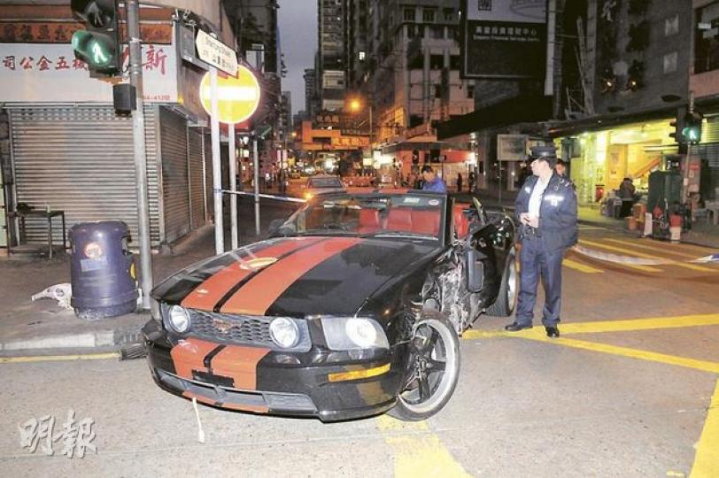 車禍後尋回的福特野馬跑車左邊車身損毀，司機卻不知所終。（蔡方山攝） 野馬跑車被尋獲時，車牌位置顯示為一個沒有登記的車牌，可見原掛着T牌的繩索被剪斷。（蔡方山攝） 車禍中，的士遭不顧而去的「野馬」撞至車頭嚴重損毁，幸未有造成重大傷亡。（蔡方山攝）