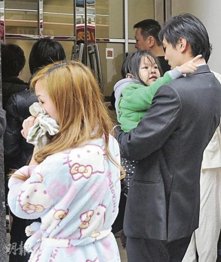 羅小姐（左）與3歲女（綠衣）在家熟睡時驚聞發生火警，出門後見到樓梯濃煙密佈，醒目女提醒她折返家中等候救援，其丈夫事後亦趕返，抱着女兒疼惜一番。（樊銳昌攝） 乾衣舖的排氣槽積聚大量棉絮毛頭，遇熱起火後湧出大量濃煙，消防員忙於撲救。（樊銳昌攝）