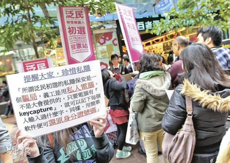 人民力量的成員則在票站旁舉起白色橫額，警告市民如果投票，將有私隱外泄的風險。（李澤彤攝）