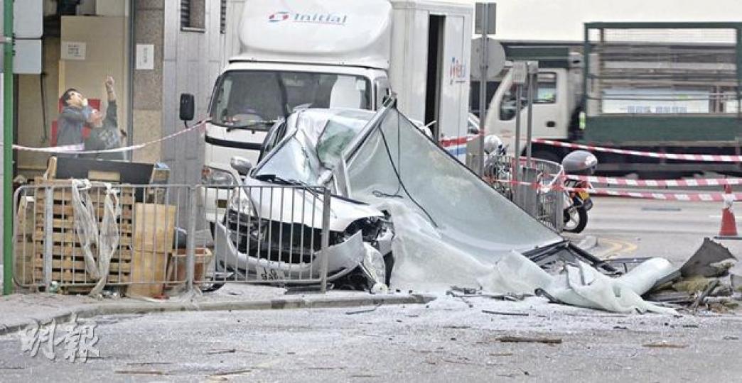 停泊中環會所街的七人房車被高空墜下的1噸重玻璃幕牆壓至猶如廢鐵，幸司機不在車廂，否則不堪設想。（李澤彤攝） 七人車廖姓司機（右）因響應停車熄匙落車「唞唞氣」而避過一劫，事後說要劏雞還神，及不會再將車停泊上址。（李澤彤攝） 中環麗嘉酒店重建地盤發生墜物意外，一塊約1噸重玻璃幕牆從12樓墜下會所街，再壓毁行人路上一輛七人車（箭嘴示）。（李澤彤攝） 墜下的一組2.5米乘4米大玻璃，面積有如圖中（綠色線）框着一組的玻璃。箭嘴位置為被飛墜幕牆擊中位置。（李澤彤攝）