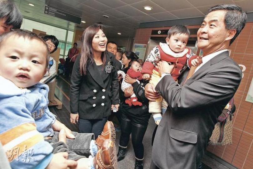 特首參選人梁振英（右一）昨日到粉嶺母嬰健康院了解服務情况。他表示，「雙非」嬰兒對本港母嬰健康院造成壓力，很不理想，建議增加醫護人手，並制訂長遠人口政策。（李紹昌攝）