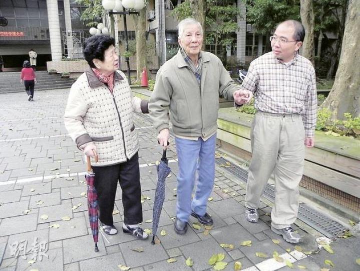 90歲的陳老先生在84歲妻子的攙扶下前往票站，難以登上5級樓梯進入投票所，最後由工作人員引領從另一入口進站投票。（李泉攝）馬英九戶籍所在地台北文山區的投票站外，選民大排長龍，有人坐着輪椅來投票。（李泉攝）