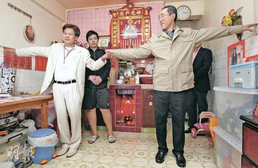特首參選人唐英年（右）與十八鄉鄉委會主席梁福元（左）在元朗東頭村村屋內手牽手「度尺」，以示有些村屋面積小，情况與丁屋不同。（李澤彤攝） （明報製圖）