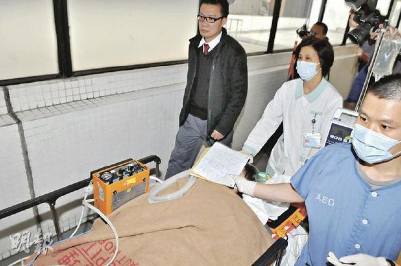 患感冒女童在校內暈倒後送院搶救,情况危殆;女童父親(左黑衣者)陪同女兒送往深切治療部。(林錫禮攝) 患感冒女童在校內暈倒後送院搶救,情况危殆;女童父親(左黑衣者)陪同女兒送往深切治療部。(林錫禮攝)