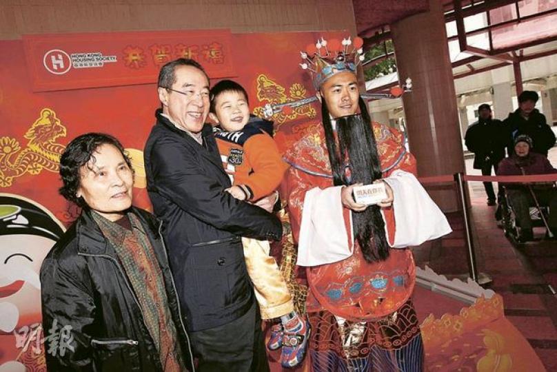特首參選人唐英年(左二)昨日到紅磡探望照顧他數十年的家傭、現已75歲的「美姐」(左一),並抱着美姐4歲的孫兒接受訪問。美姐大讚唐為人忠直、大方,適合做特首。右一的「財神」,是唐英年競選辦副秘書長劉鳴煒扮演。(李紹昌攝) 特首參選人唐英年(左二)昨日到紅磡探望照顧他數十年的家傭、現已75歲的「美姐」(左一),並抱着美姐4歲的孫兒接受訪問。美姐大讚唐為人忠直、大方,適合做特首。右一的「財神」,是唐英年競選辦副秘書長劉鳴煒扮演。(李紹昌攝)