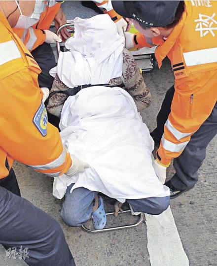 在油麻地家中將雜物掟落街女子，在警方破門入內制服時高叫「張國榮我愛你」，事後由救護員綁着送院。（蔡方山攝） 女子丟棄雜物案，現場樓層電梯大堂及後樓梯遍佈摔破的神像碎片。（林錫禮攝） 雜物擲中一隻雀鳥，牠受傷流血死在路上。（蔡方山攝）