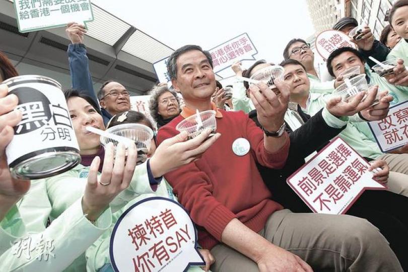 特首參選人梁振英(中)昨到尖沙嘴為「梁粉(即梁振英之友)」打氣,他們一同吃加有花奶的涼粉,表明「黑白分明」,反官商勾結,說要藉此「為市民降火」。梁振英昨要求政府全面公開涉及西九概念規劃比賽的全部檔案。(李紹昌攝) 特首參選人梁振英(中)昨到尖沙嘴為「梁粉(即梁振英之友)」打氣,他們一同吃加有花奶的涼粉,表明「黑白分明」,反官商勾結,說要藉此「為市民降火」。梁振英昨要求政府全面公開涉及西九概念規劃比賽的全部檔案。(李紹昌攝)