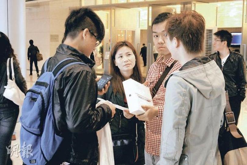 記者現場觀察,約有10多名疑是「收買佬」(包括黑衫女子及紅格衫男子)停留店外,其間有剛離店的iPad買家趨前查詢,不少人問價後都沒有交易。(林耀華攝) 記者現場觀察,約有10多名疑是「收買佬」(包括黑衫女子及紅格衫男子)停留店外,其間有剛離店的iPad買家趨前查詢,不少人問價後都沒有交易。(林耀華攝)