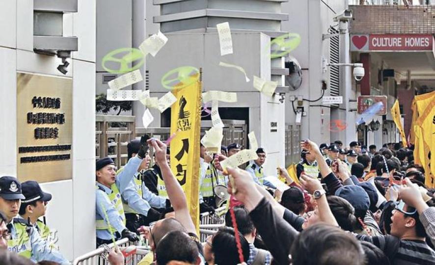 示威者由灣仔會展遊行至西環中聯辦後,分批向中聯辦閘門投擲溪錢及放出膠製竹蜻蜓(寓意小圈子,圖),又焚燒自製的《基本法》和《中英聯合聲明》紙牌,象徵香港政治遭中央直接介入,香港進入黑暗時代,一國兩制已死。(郭慶輝攝) 示威者由灣仔會展遊行至西環中聯辦後,分批向中聯辦閘門投擲溪錢及放出膠製竹蜻蜓(寓意小圈子,圖),又焚燒自製的《基本法》和《中英聯合聲明》紙牌,象徵香港政治遭中央直接介入,香港進入黑暗時代,一國兩制已死。(郭慶輝攝)