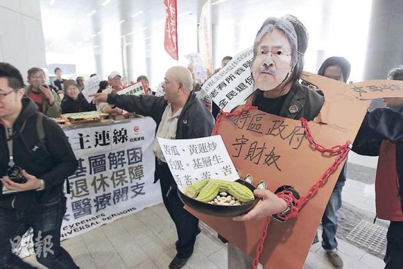 多名泛民議員昨日提出修正案,針對特首曾蔭權、財政司長曾俊華等,削減他們的薪酬,最終議案遭否決。圖為「長毛」梁國雄扮「曾俊華」示威,手持苦瓜反映基層生活艱苦。(郭慶輝攝) 多名泛民議員昨日提出修正案,針對特首曾蔭權、財政司長曾俊華等,削減他們的薪酬,最終議案遭否決。圖為「長毛」梁國雄扮「曾俊華」示威,手持苦瓜反映基層生活艱苦。(郭慶輝攝)