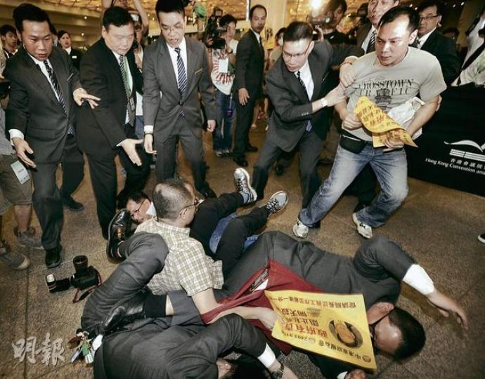 中港家庭權益會約30人,昨早趁醫管局在灣仔會展舉行研討會期間到場請願,不滿私家醫院單非孕婦的分娩費用過高,要求政府管制,會展保安築起人牆,示威者嘗試突圍時一度與保安衝突,當中權益會組織者曾冠榮(格仔衫)與兩名保安被推跌,一名《蘋果日報》攝影記者亦跌倒,頭部受傷送院,治理後出院。(余俊亮攝) 中港家庭權益會約30人,昨早趁醫管局在灣仔會展舉行研討會期間到場請願,不滿私家醫院單非孕婦的分娩費用過高,要求政府管制,會展保安築起人牆,示威者嘗試突圍時一度與保安衝突,當中權益會組織者曾冠榮(格仔衫)與兩名保安被推跌,一名《蘋果日報》攝影記者亦跌倒,頭部受傷送院,治理後出院。(余俊亮攝)