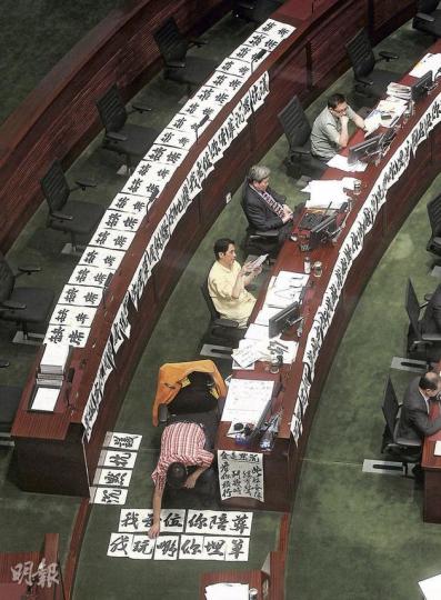 工聯會王國興(最前方面向地上)不甘人民力量的拉布戰,逕自寫毛筆字、貼大字報發泄,「沉默抗議」、「你拉布我埋單」、「我出位你陪葬」、「缺席」等字句,至晚上有關大字已貼滿王國興座位前後三排。左二起為黃國健、潘佩璆、葉偉明。(李澤彤攝) 拉布戰主要靠人民力量黃毓民(左)、陳偉業(右)及社民連主席梁國雄出招,剛於上周完成白內障及眼角膜手術的黃毓民,昨偶爾要滴眼藥水。(李澤彤攝) 朝九晚十的會議,政制及內地事務局長譚志源不顧鏡頭也要站起來拉拉筋,以打這場持久戰。(李澤彤攝) 工聯會王國興(最前方面向地上)不甘人民力量的拉布戰,逕自寫毛筆字、貼大字報發泄,「沉默抗議」、「你拉布我埋單」、「我出位你陪葬」、「缺席」等字句,至晚上有關大字已貼滿王國興座位前後三排。左二起為黃國健、潘佩璆、葉偉明。(李澤彤攝) 拉布戰主要靠人民力量黃毓民(左)、陳偉業(右)及社民連主席梁國雄出招,剛於上周完成白內障及眼角膜手術的黃毓民,昨偶爾要滴眼藥水。(李澤彤攝) 朝九晚十的會議,政制及內地事務局長譚志源不顧鏡頭也要站起來拉拉筋,以打這場持久戰。(李澤彤攝)