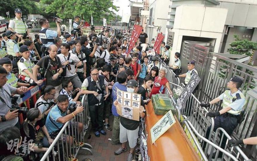 遊行隊伍到達中聯辦後,將棺材、紙坦克等示威物品放在門外,警員以兩重鐵馬隔開示威者與中聯辦,並有警員手持攝影機記錄示威情况。(李澤彤攝) 有示威者在中聯辦門外展示畫上交叉的警務處長曾偉雄的相片,以示不滿。(余俊亮攝) 遊行隊伍到達中聯辦後,將棺材、紙坦克等示威物品放在門外,警員以兩重鐵馬隔開示威者與中聯辦,並有警員手持攝影機記錄示威情况。(李澤彤攝) 有示威者在中聯辦門外展示畫上交叉的警務處長曾偉雄的相片,以示不滿。(余俊亮攝)