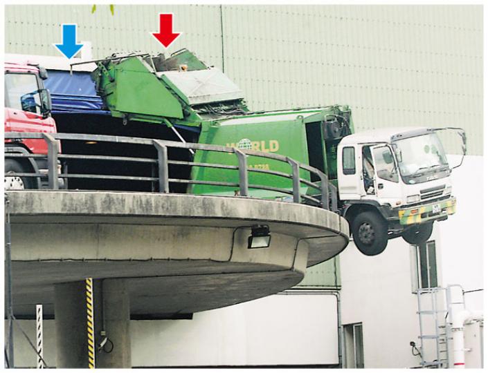 肇事垃圾車駛經垃圾轉運站出口(藍箭嘴示)時,因忘記收回尾冚(紅箭嘴示)而撞向橫樑,令車頭「昂起」,險衝出圍欄墜下10米橋底。(黃雄攝) 肇事垃圾車駛經垃圾轉運站出口(藍箭嘴示)時,因忘記收回尾冚(紅箭嘴示)而撞向橫樑,令車頭「昂起」,險衝出圍欄墜下10米橋底。(黃雄攝)
