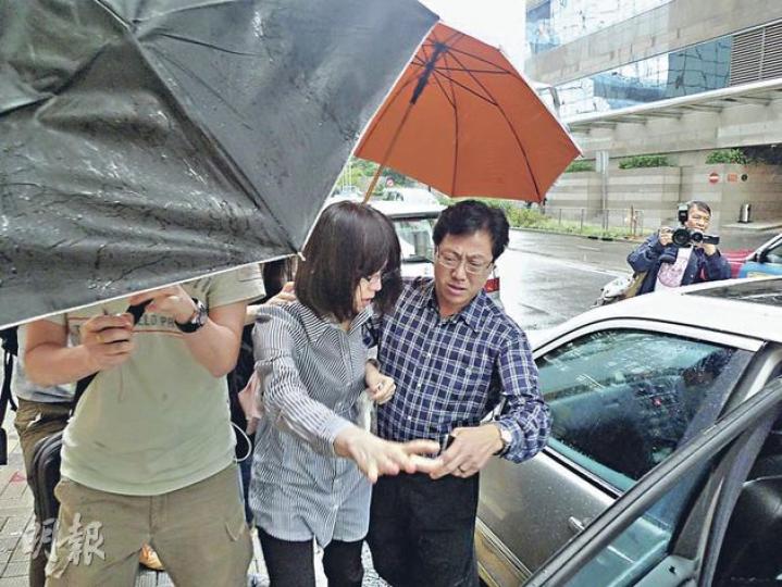 未能「共患難」,亦能風雨同路。前東區區議員陳添勝(右)安排車輛,接走協助他工作多年的女被告伍小蓮(右),伍的朋友則打傘阻擋拍攝。(何偉畧攝) 未能「共患難」,亦能風雨同路。前東區區議員陳添勝(右)安排車輛,接走協助他工作多年的女被告伍小蓮(右),伍的朋友則打傘阻擋拍攝。(何偉畧攝)