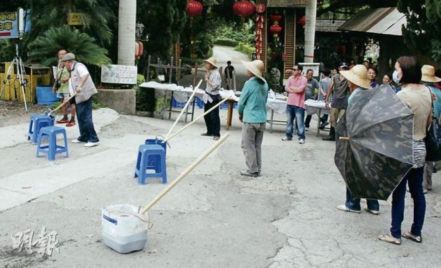 村民除帶備鐵槌、耕作刀具及鐵製家具與警方及地政官員對峙外,更以3桶有機肥料架起「糞陣」(圖中白色桶及兩藍色桶),圖阻止工程人員入村執行清拆令,有清拆承建商昨投訴指離開時被人潑糞。(雲錦鋒攝) 荔枝山莊股東梁福元(左一)在警員到場戒備後,出來與警方行動負責人握手,並與地政總署高級地政主任麥偉坤(右一綠衣者)入村談判,梁最終讓政府派員入山莊測量,以「釐清官地與私地界線」。(雲錦鋒攝) 警員到場下,山莊村民讓步,地政總署人員昨傍晚終可進入山莊測量,但仍未能展開清拆僭建物行動。(雲錦鋒攝) 村民除帶備鐵槌、耕作刀具及鐵製家具與警方及地政官員對峙外,更以3桶有機肥料架起「糞陣」(圖中白色桶及兩藍色桶),圖阻止工程人員入村執行清拆令,有清拆承建商昨投訴指離開時被人潑糞。(雲錦鋒攝) 荔枝山莊股東梁福元(左一)在警員到場戒備後,出來與警方行動負責人握手,並與地政總署高級地政主任麥偉坤(右一綠衣者)入村談判,梁最終讓政府派員入山莊測量,以「釐清官地與私地界線」。(雲錦鋒攝) 警員到場下,山莊村民讓步,地政總署人員昨傍晚終可進入山莊測量,但仍未能展開清拆僭建物行動。(雲錦鋒攝)