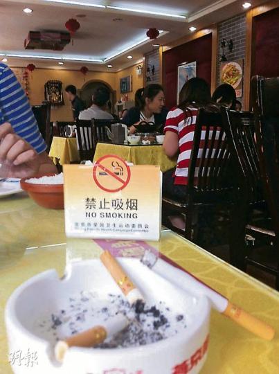 在北京的餐館,雖然枱面放着禁止吸煙的牌子,但侍應照樣向客人提供煙灰盅,允許吸煙。(劉洪慶攝) 在北京的餐館,雖然枱面放着禁止吸煙的牌子,但侍應照樣向客人提供煙灰盅,允許吸煙。(劉洪慶攝)