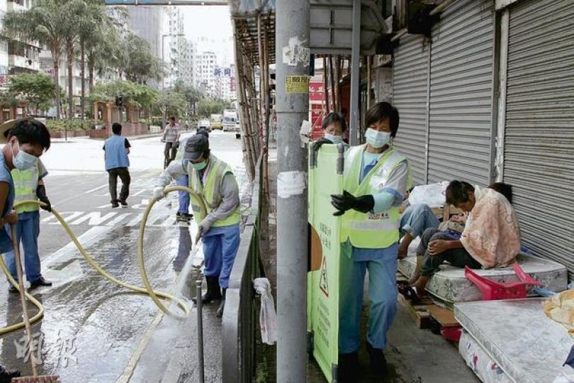食環署外判工人昨開喉清洗行人路與馬路,其間以隔水板隔開露宿者「竇口」,露宿者未有被驅趕或勸喻離開。(何偉畧攝) 食環署外判工人昨開喉清洗行人路與馬路,其間以隔水板隔開露宿者「竇口」,露宿者未有被驅趕或勸喻離開。(何偉畧攝)