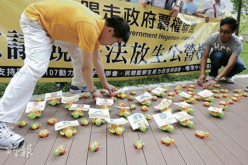 立法會昨日繼續審議競爭法,有團體在大樓外示威,並「放生」機械烏龜,諷刺草案放生公營機構。(劉焌陶攝) 立法會昨日繼續審議競爭法,有團體在大樓外示威,並「放生」機械烏龜,諷刺草案放生公營機構。(劉焌陶攝)
