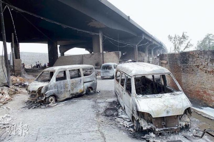爆炸現場，多輛車被燒剩車架。（明報記者攝）