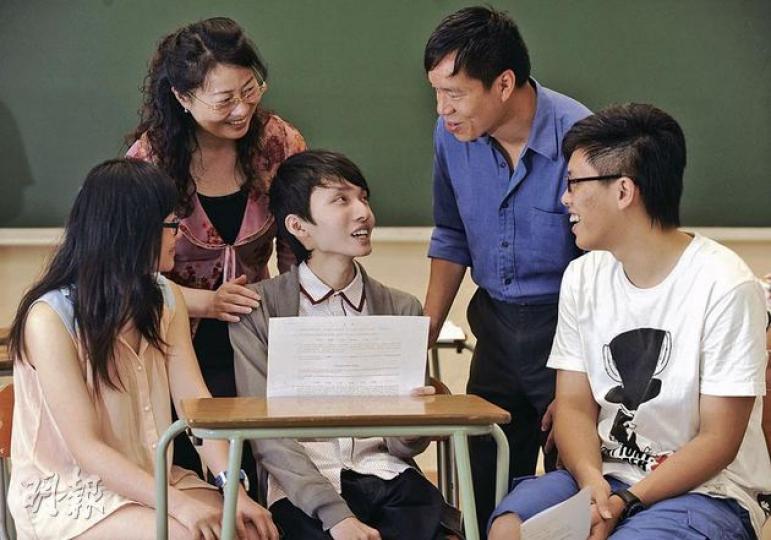 「無腸少年」唐國榮（中）昨由母親（後排左）陪同，返回校園取高考成績單，成績雖未如理想，但得班主任謝以輝（後排右）及同窗鼓勵，他將積極尋找升學機會。（余俊亮攝）