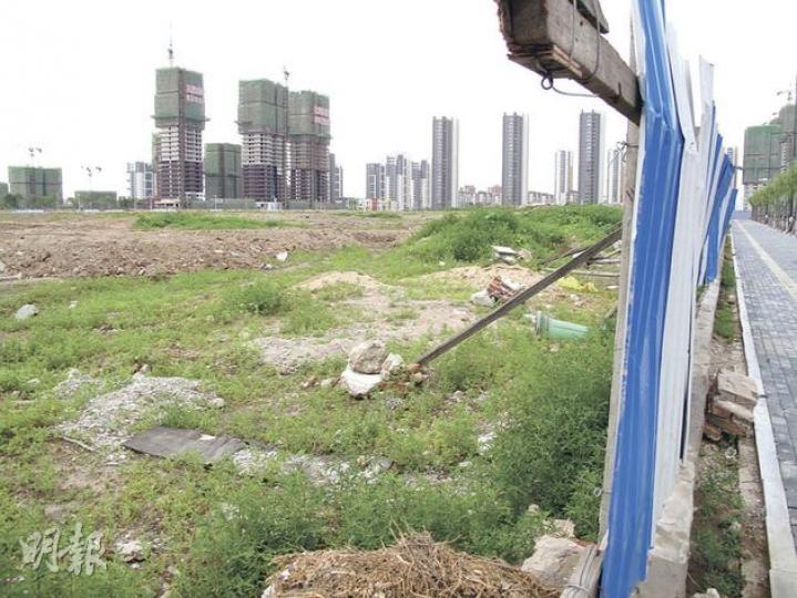 本報記者親赴瀋陽視察，發現地皮尚未開工，雜草叢生，圍板破爛任人出入。附近萬科的項目已相繼建成，並且賣得火熱。（明報記者攝）