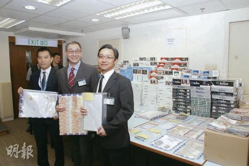 西九龍總區刑事部警司盧國基（中）展示在全港反黑反黃賭毒行動中檢獲的大批證據，包括懷疑賭款或犯罪得益、馬纜、私煙等，行動中共拘捕47人，包括13名黑幫骨幹，主要為「水房」成員。（雲錦鋒攝）