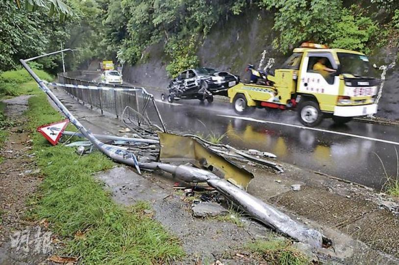 大埔公路3車相撞意外中，一大段路邊鐵欄被掃毁，疑強行切線爬頭惹禍的私家車嚴重損毁，意外後由拖車拖走。（林錫禮攝）