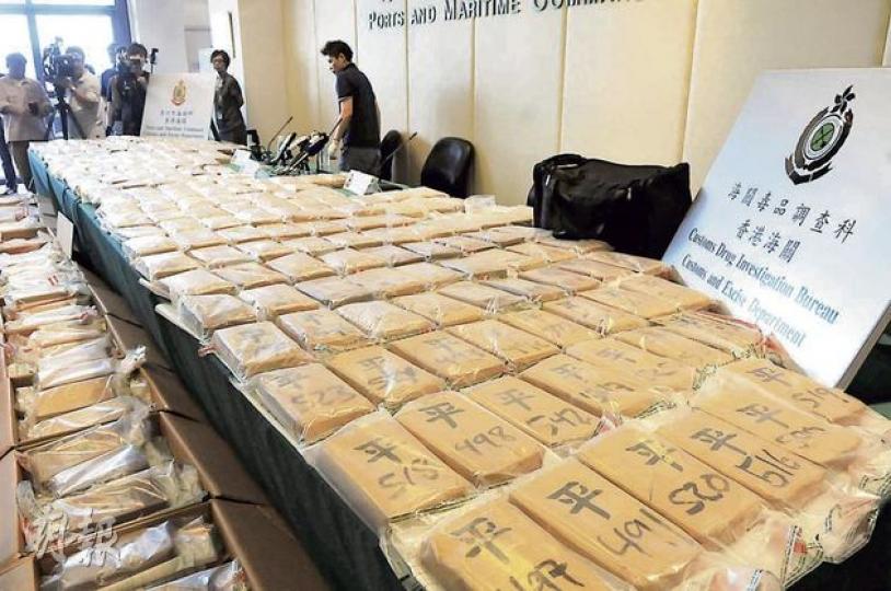 海關檢獲541塊可卡因「磚」，市值逾7.6億元，是本港歷來最大宗毒品案。可卡因磚包裝袋上寫上「平」字及三位數號碼，相信是方便識別及分銷。（林錫禮攝）海關毒品調查科總監李章榮（中）與同僚展示檢獲的可卡因磚及用作收藏毒品的黑色尼龍袋。（林錫禮攝）