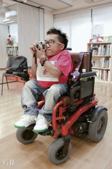 自小要透過輪椅代步的鄭啟文（Kevin）稱，即使在輪椅上拍攝有一定難度，但他堅持透過攝影，帶出弱勢社群的生活，令社會不會遺忘他們。（黃俊鋒攝）