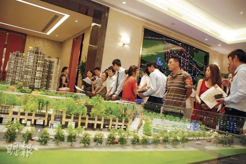 二度減息再次觸動內地民眾買樓情緒。深圳一個未正式開售的樓盤，前日只不過接受買家登記，也吸引到數百名市民到場，部分稱擔心樓價會反彈而不再觀望。圖為一眾買家圍在樓盤模型旁聽職員推介。（陳子凌攝）