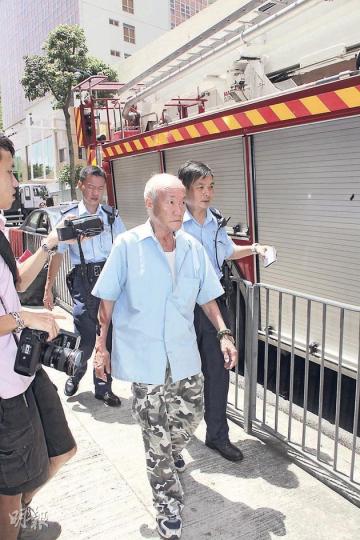 66歲的周伯堅拒交出居住多年的單位，與妻子在單位內貼出多張「大字報」，並在室內淋天拿水，驚動警方及消防員，經談判專家游說個多小時，終自行開門，陪同情緒激動的妻子送院檢查。（林錫禮攝） 警方出動身穿防暴盔甲的警員，手持盾牌到場戒備。（林錫禮攝）