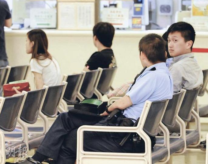 新歡舊愛大打出手，兩男一女送院治理。候診期間前男友（警員旁灰衣者）面對坐在前排的舊女友（左一）與其新歡（黑衣），狀甚無奈。（蔡方山攝）
