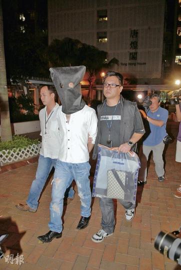 警方破獲中港台電話騙案集團及拘捕3人,警員昨晚把其中一名疑犯蒙頭押返將軍澳唐明苑寓所蒐證。(伍浦鋒攝) 警方破獲中港台電話騙案集團及拘捕3人,警員昨晚把其中一名疑犯蒙頭押返將軍澳唐明苑寓所蒐證。(伍浦鋒攝)