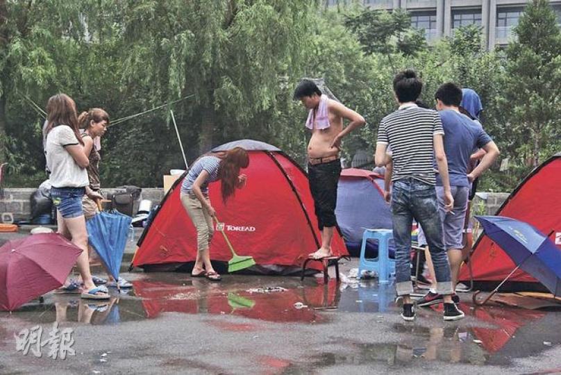 昨日傍晚下過一場雨後,露宿的「蟻族」們清理垃圾。(明報記者攝) 昨日傍晚下過一場雨後,露宿的「蟻族」們清理垃圾。(明報記者攝)