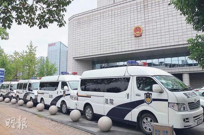昨日在合肥中院門口,6輛警車一字排開,阻擋住法院大門。(明報記者攝) 昨日在合肥中院門口,6輛警車一字排開,阻擋住法院大門。(明報記者攝)