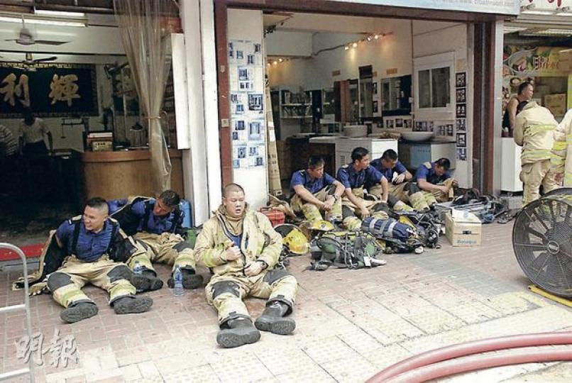 消防員昨穿梭於起火的荔枝角道14層高舊樓不斷疏散及拯救住客,大半小時後部分首批到場消防坐在地下喘氣及稍事休息,由其他同僚接力繼續救人。(雲錦鋒攝) 消防員昨穿梭於起火的荔枝角道14層高舊樓不斷疏散及拯救住客,大半小時後部分首批到場消防坐在地下喘氣及稍事休息,由其他同僚接力繼續救人。(雲錦鋒攝)