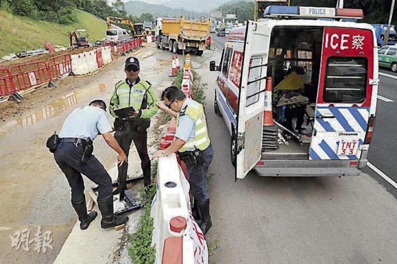 交通警模型昨首天「出勤」,其在吐露港公路所駐守位置外的400米剛巧發生一宗交通意外,事後警方將意外車輛拖到「交警」附近調查,其後順道安排「交警收工」,由同僚將模型搬上警車。(衛永康攝) 交通警模型昨首天「出勤」,其在吐露港公路所駐守位置外的400米剛巧發生一宗交通意外,事後警方將意外車輛拖到「交警」附近調查,其後順道安排「交警收工」,由同僚將模型搬上警車。(衛永康攝)