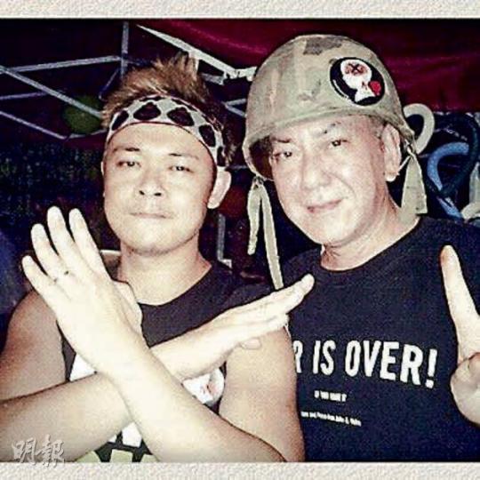 黃秋生(右)戴着貼有反洗腦貼紙的頭盔,與梁祖堯到政總的公民廣場以示支持。(微博圖片) 黃秋生(右)戴着貼有反洗腦貼紙的頭盔,與梁祖堯到政總的公民廣場以示支持。(微博圖片)