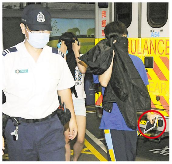 彩虹邨金碧樓被搶劫消夜的男事主(右藍衣者),事後由女親友陪同送院,其間不忘帶同平板電腦(紅圈示)。(蔡方山攝) 彩虹邨金碧樓被搶劫消夜的男事主(右藍衣者),事後由女親友陪同送院,其間不忘帶同平板電腦(紅圈示)。(蔡方山攝)