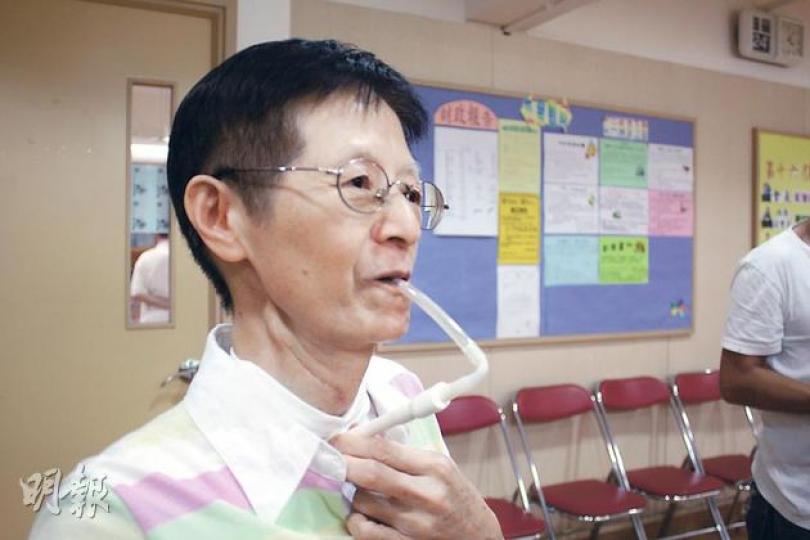 喉嚨及舌頭皆被切除的黃麗珍借助俗稱喇叭仔的氣動式喉頭發聲,但說話仍然語句不清,要靠手勢輔助。(楊德銘攝) 喉嚨及舌頭皆被切除的黃麗珍借助俗稱喇叭仔的氣動式喉頭發聲,但說話仍然語句不清,要靠手勢輔助。(楊德銘攝)